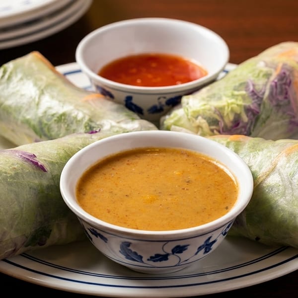 Four fresh spring rolls filled with vegetables, served with peanut and chili dipping sauces.